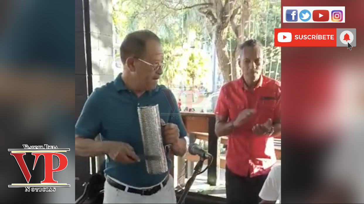 Mira al alcalde de SFM tocando la güira junto a la banda municipal